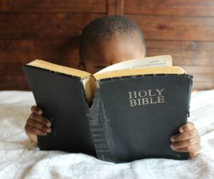Toddler reading a well-used Bible