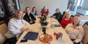 Women sitting around a meal table, Christmas theme