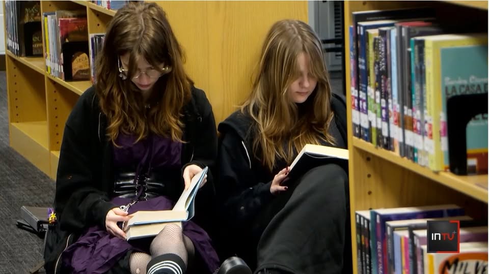 Two girls reading on floor at a library